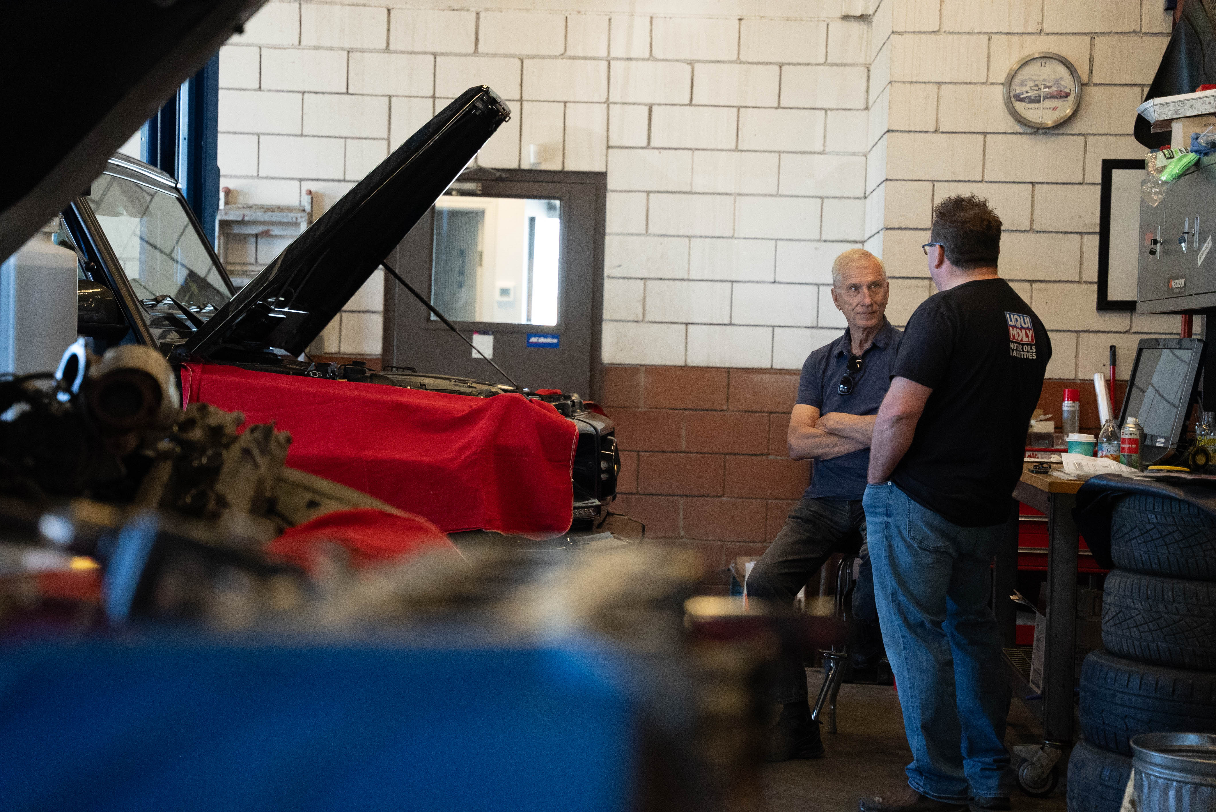Eurospec team members discussing work beside a vehicle in the shop